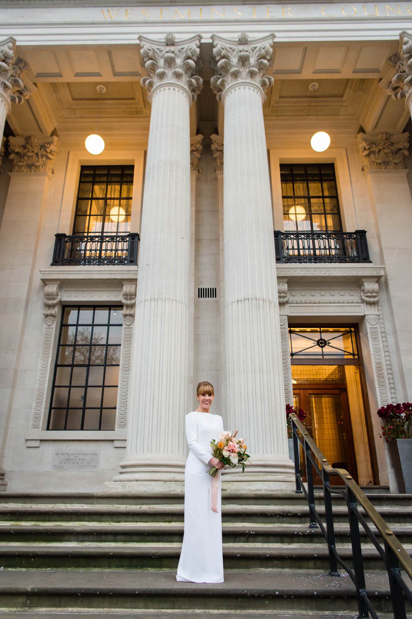 A bride wearing a Roland Mouret bridal gown on the steps of Marylebone Town Hall